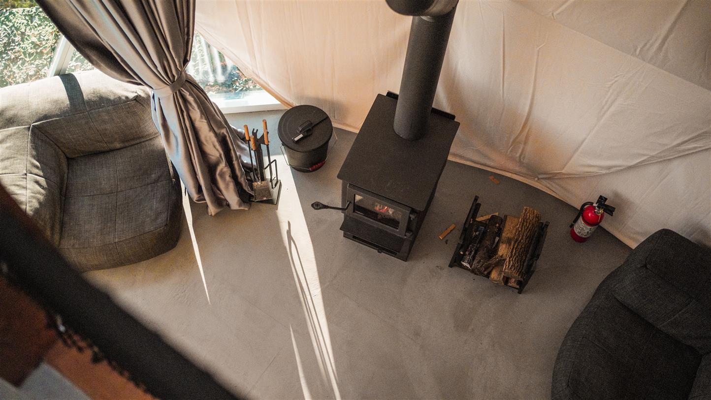 Coin lounge avec poêle à bois et fauteuil de détente